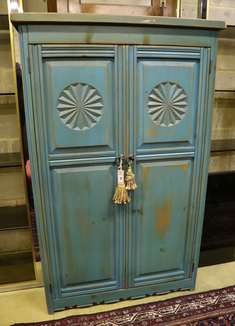 A distressed carved and blue-painted pine double wardrobe, width 96cm